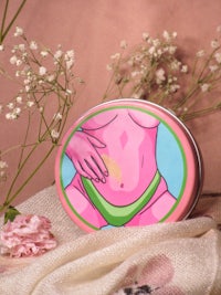 a pink tin with flowers and a picture of a woman in a bikini